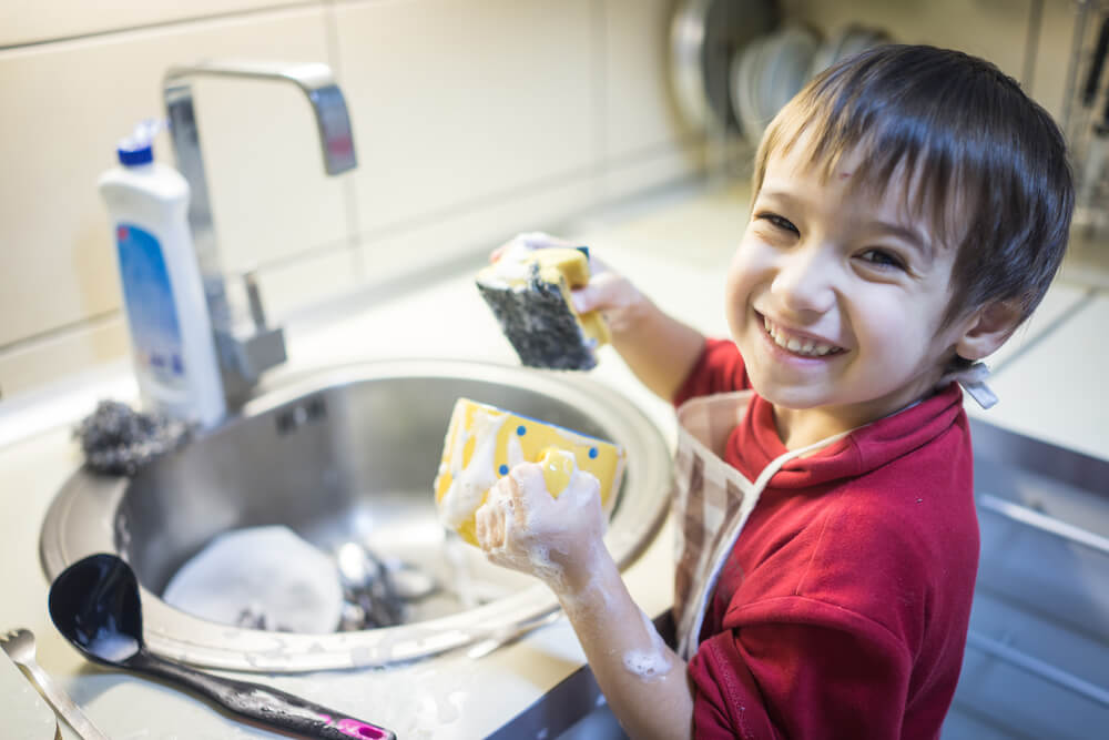 creative chores for kids - little boy cleaning the dishes